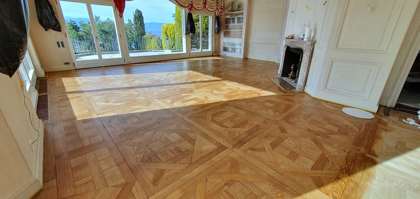 Grand séjour avec parquet en panneaux et cheminée en marbre