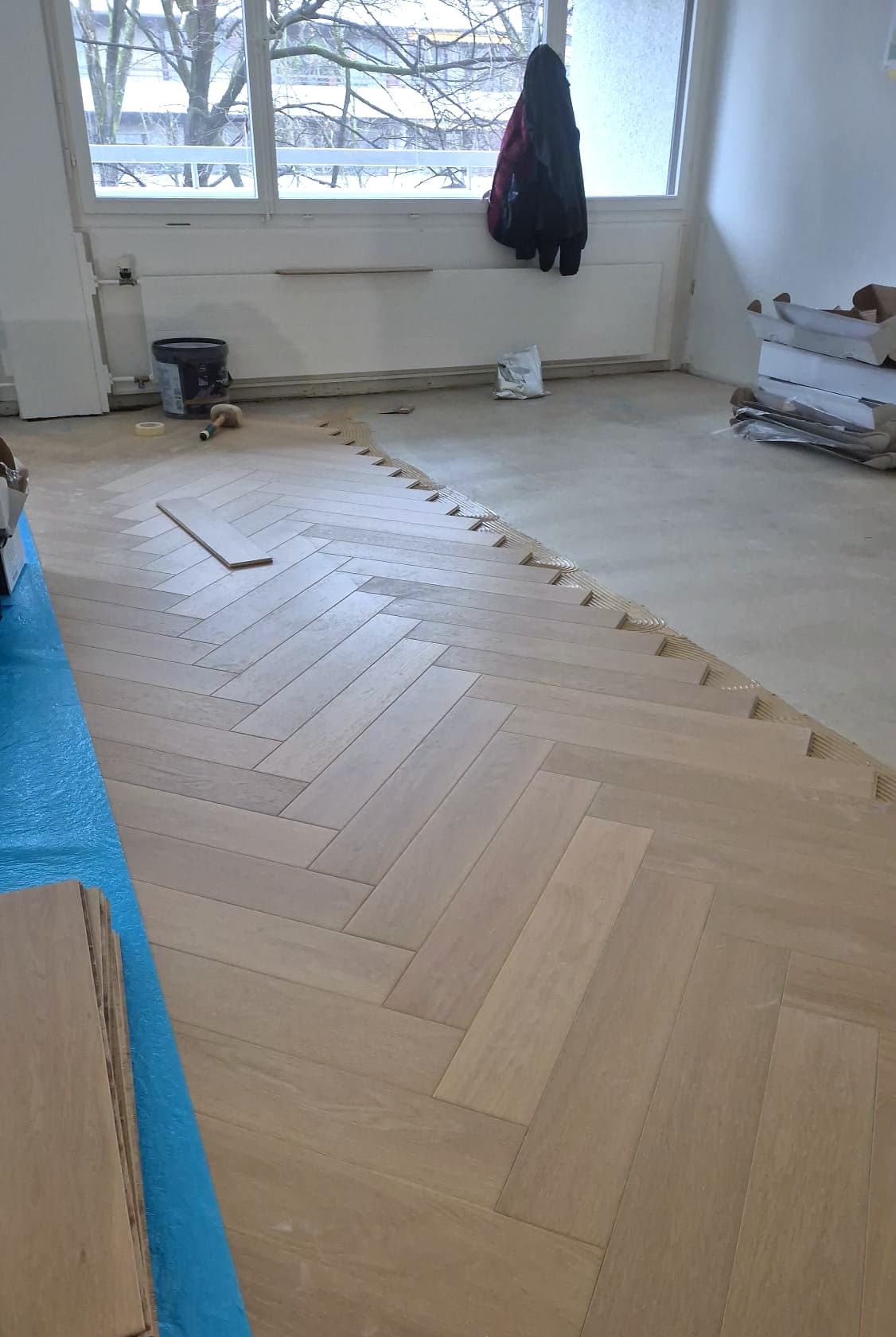 Pose du parquet à bâtons rompus, lames posées sur la colle peignée