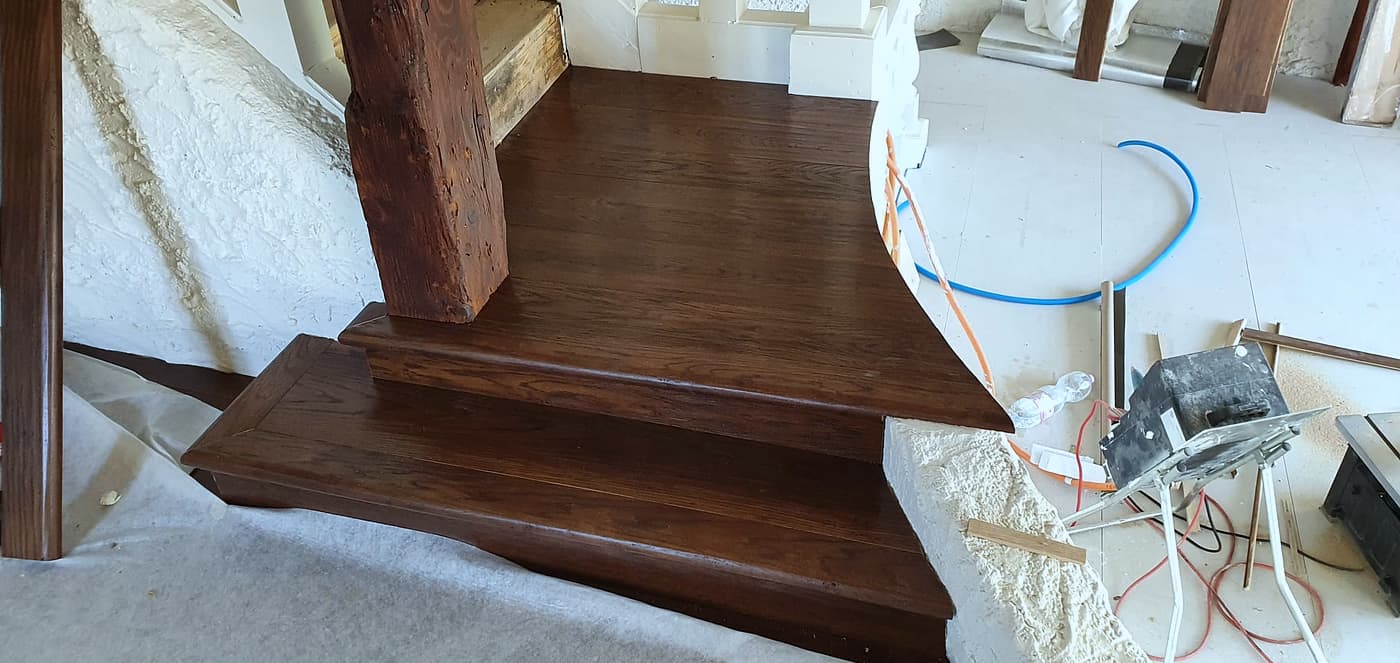 Détail du palier en bois teinté, nez de marche arrondi
